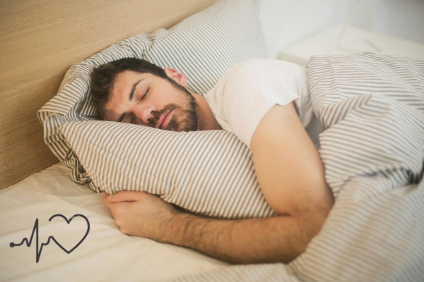 A young man peacefully sleeping in bed with striped pillows